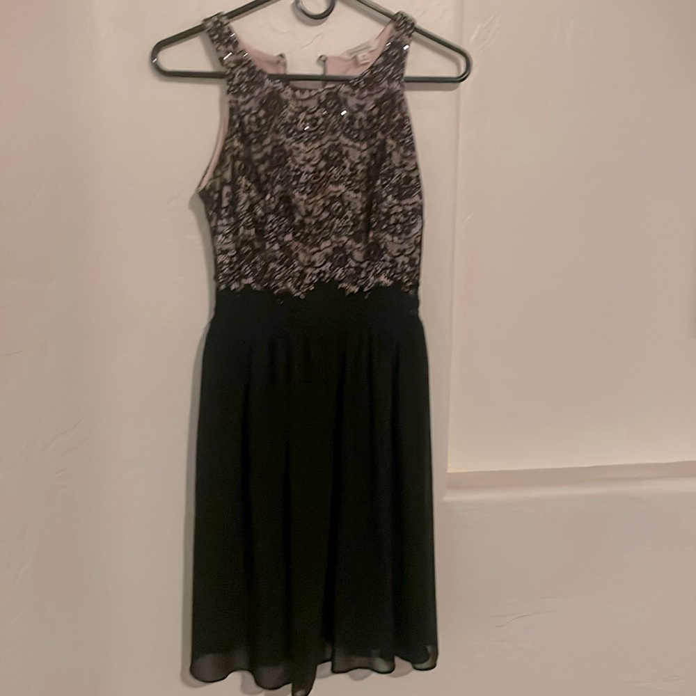 Black lace dress with pink lining and sparkly sequins on the top of the dress